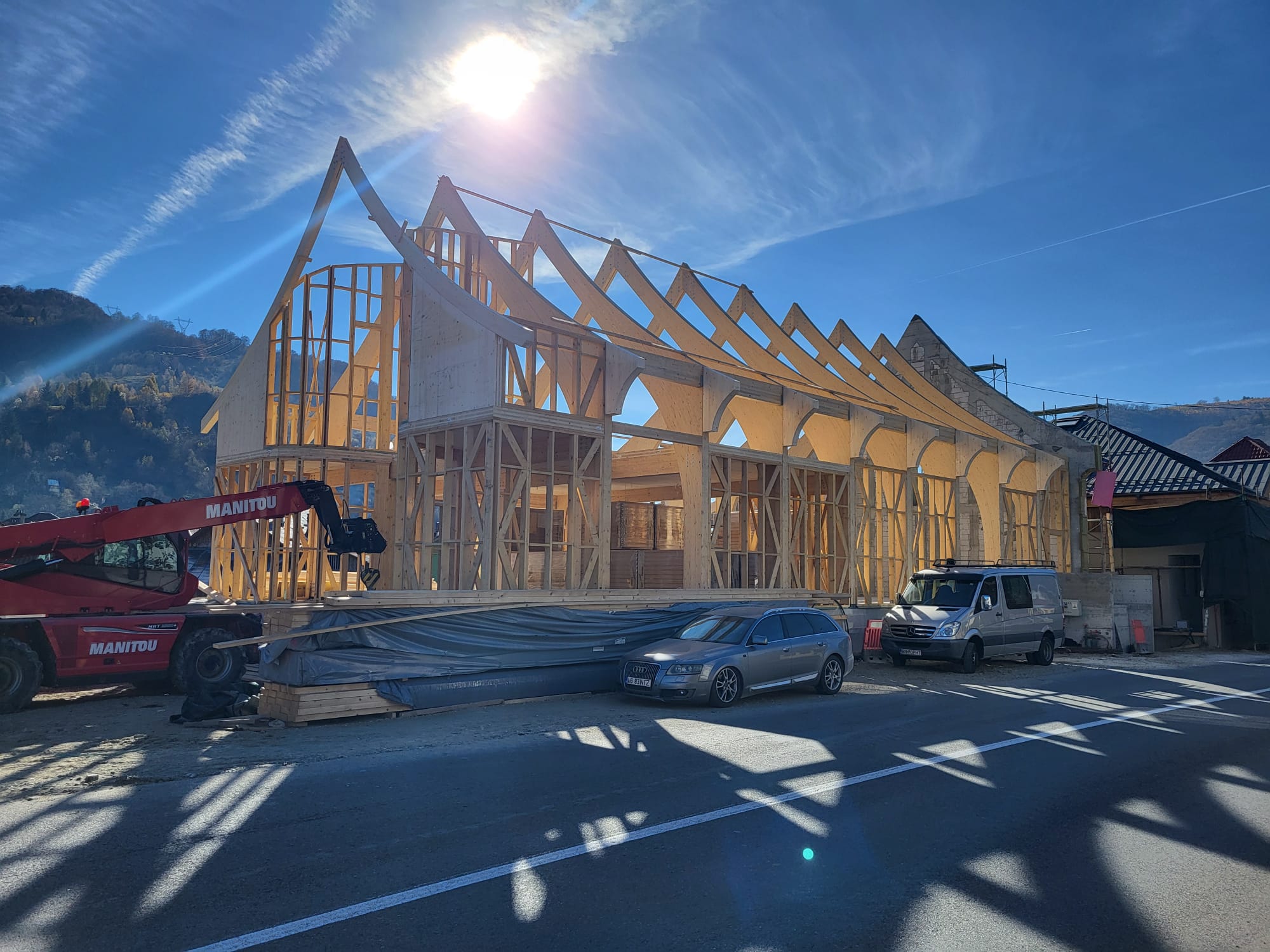 Timber frame structure being erected on site — pre-numbered panels from the factory